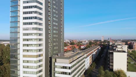 El-Dron-Desciende-Hacia-El-Costado-Del-Edificio,-Y-También-Vemos-Apartamentos-Vacíos-Y-Sin-Uso.