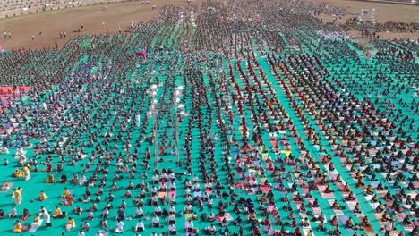 Luftaufnahmen-Von-Menschen,-Die-In-Einem-Stadion-In-Ahmednagar,-Indien,-Anlässlich-Des-Internationalen-Yoga-Tages-Zusammen-Mit-Schülern-Yoga-Machen