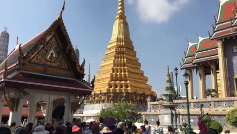 A-famous-wat-in-Bangkok,-Wat-phra-kaew-filled-with-tourists-to-visit-monks-and-pray-for-buddha,-panning