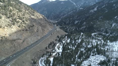 Surreal-aerial-clip-of-the-Interstate-cutting-through-the-Colorado-Mountains-and-the-town-of-Idaho-Springs