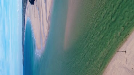 Cornish-Beach-In-Hayle-Mit-Vertikaler-Drohne,-Die-über-Türkisfarbenes-Wasser-Nach-Unten-Schwenkt