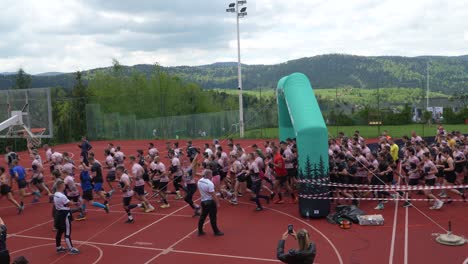 Große-Gruppe-Von-Läufern-Am-Start-Eines-Berg-Hindernislaufs-Auf-Einer-Roten-Laufstrecke