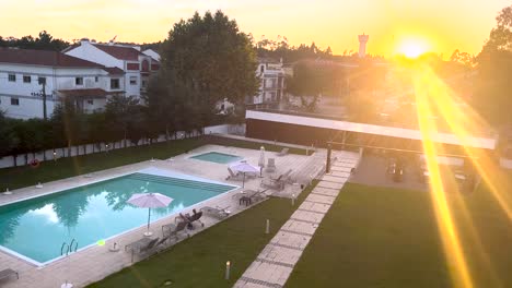 Amanecer-Sobre-La-Piscina-Del-Complejo-En-El-Jardín-Del-Hotel-De-Vacaciones,-Ningún-Pueblo