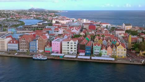 Revealing-aerial-shot-of-Willemstad-waterfront-with-its-colorful-houses-and-waterfront