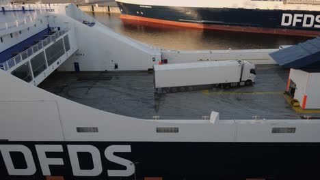 On-the-DFDS-ferry,-trucks-with-semi-trailers-are-parked-in-reverse-on-the-open-deck