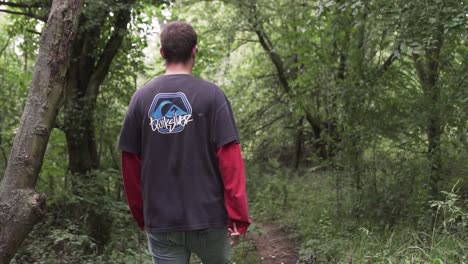 Young-man-walking-alone-in-green-and-wild-forest