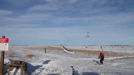 Snowkiter-taking-advantage-of-a-Chinook-on-a-beautiful-winters-day-launches-kite-and-skis-across-a-frozen-reservoir-in-Southern-Alberta