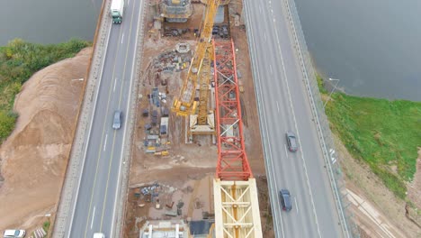 Carretera-Muy-Transitada-Y-Sitio-De-Construcción-Para-Un-Nuevo-Puente-Sobre-El-Río-Neris,-Vista-Aérea-De-Drones