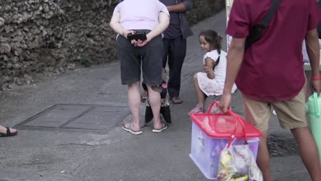 Angeketteter-Gefangener-Affe,-Der-Zum-Fotografieren-Verwendet-Wird-Und-Das-Bein-Einer-Touristenfrau-Umarmt