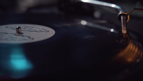 Slow-motion-panning-from-right-to-left-over-a-vinyl-record-playing-on-a-turntable-at-a-party