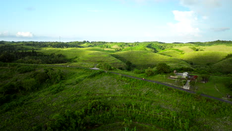 Across-Teletubbies-hills,-girl-riding-scooter,-beautiful,-serene,-aerial