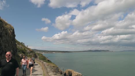 People-hiking-on-a-trail-along-the-coast-on-a-sunny-day