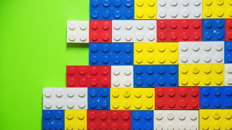 Stop-motion-transition-with-legos,-top-view,-with-green-screen-in-the-background