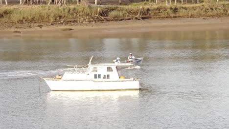 Small-boat-with-two-occupants-traveling-along-the-Fitzroy-River,-Rockhampton