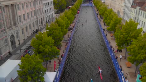 Toma-Aérea-De-Personas-Navegando-En-Kayak-Por-El-Canal-En-El-Centro-De-La-Ciudad