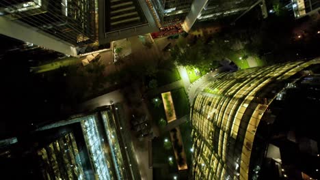 Vista-Aérea-En-Espiral-De-Edificios-Modernos-Iluminados-Por-La-Noche,-Nueva-Las-Condes,-Distrito-Financiero-De-Santiago,-Chile.