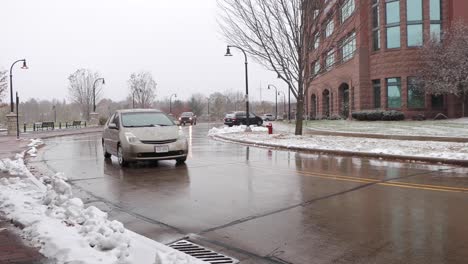 A-car-slowly-drives-around-the-cul-de-sac-near-phoenix-park-in-Eau-Claire-Wisconsin-while-it's-beginning-to-snow