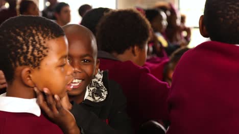 African-black-student-showing-thumbs-up-looking-at-camera-and-playing-with-friend