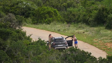 Two-tourists-breaking-national-park-rules-by-exiting-their-SUV-to-take-photos,-a-dangerous-and-risky-practice