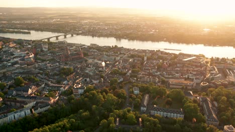 Mainz-Drohnenaufnahme-Der-Stadt-Im-Goldenen-Morgenlicht-Aus-Der-Luft-Mit-Einer-Drohne-Und-Frischen-Bäumen-Und-Der-Alten-Brücke-Im-Hintergrund