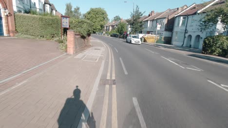 Commuter-cycling-with-a-helmet-mounted-action-camera-on-Pinner-Road,-Harrow