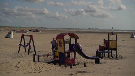 Children-playing-on-playground-swings-and-slide-on-the-beach