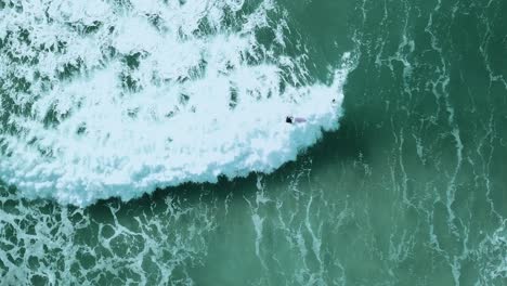 Surfers-trying-to-swim-through-breaking-waves