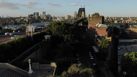 Antena-Elevándose-Sobre-El-Puente-Del-Puerto-De-Sidney-Y-El-Horizonte-En-Segundo-Plano.