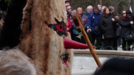 Funny-and-somewhat-scary-mask-with-red-elongated-nose-and-furry-face-jumping-up-and-down-in-traditional-dance