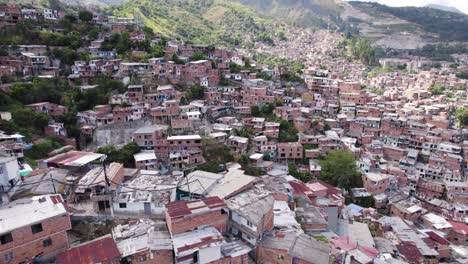 Dense-population-of-homes-on-hillside-in-Communa-13-Medellin-Colombia,-aerial
