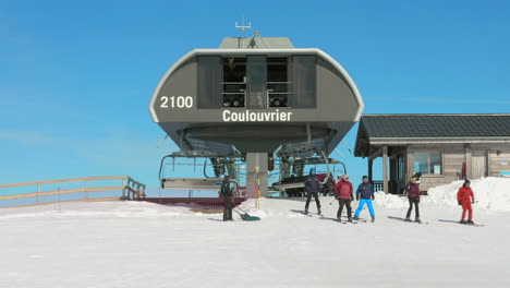 Profile-view-of-Ski-resort-with-chairlift-and-tourists-skiing-on-French-Alps,-Flaine,-France-during-morning