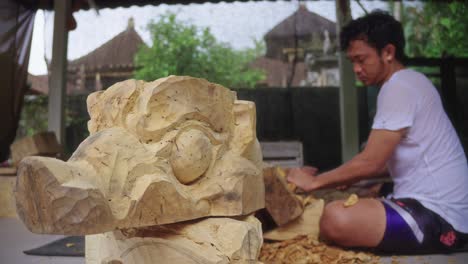 Máscara-De-Barong-Bangkal-Con-Un-Tallador-De-Madera-Balinés-Trabajando-En-El-Fondo