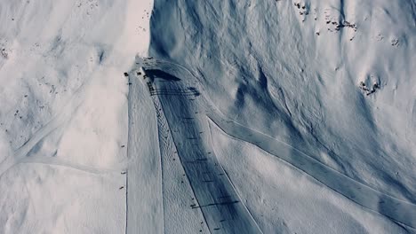 Mountain-ski-lift-station-in-snowy-Alps,-aerial