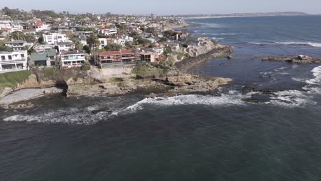 Aerial-orbit-of-houses-on-oceanside-cliff-edge-in-San-Diego,-California-on-a-sunny-day