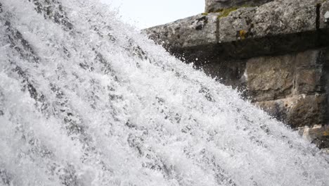 Nahaufnahme-Von-Der-Spitze-Eines-Staudammwehrs-Mit-Wasser,-Das-Wie-Ein-Wasserfall-über-Die-Spitze-Stürzt
