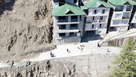 Close-up-aerial-view-of-a-building-with-green-roofs-next-to-an-exposed-rocky-cliff