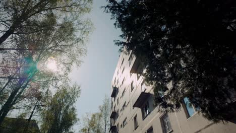 Hermosa-Llamarada-Solar-Y-Reflejo-En-Una-Toma-De-ángulo-Bajo-De-Un-Bloque-De-Apartamentos-Antiguo