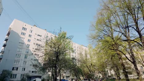 White-tall-Russian-apartment-building-block-in-sunlight-low-angle-push-in