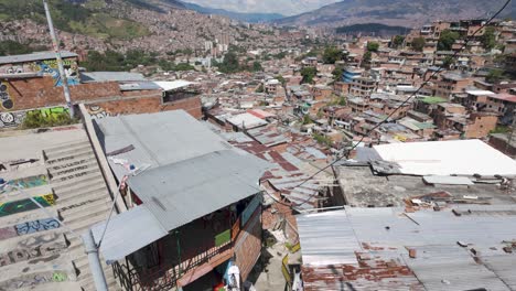 Pan-up-from-top-of-stairs-across-dense-populated-valley-of-Communa-13-in-Medellin-Colombia