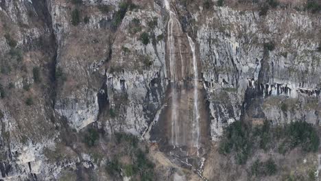 Die-Luftaufnahme-Einer-Drohne-Zeigt-Einen-Atemberaubenden-Wasserfall,-Der-Vom-Berg-Kommt-Und-Den-See-Am-Walensee-In-Quinten,-Schweiz,-Ertrinken-Lässt