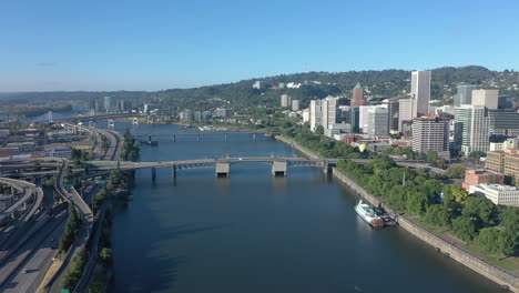 Portland,-Oregon,-Drone-Volando-Hacia-Atrás-Sobre-El-Río-Willamette-Revelando-El-Puente