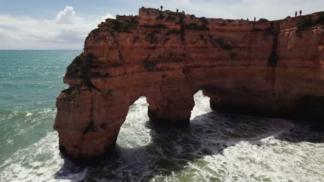 Zwei-Natürliche-Bögen-Mit-Felsnadeln-Und-Wellen,-Die-Auf-Die-Malerischen-Klippen-Der-Estrada-Da-Caramujeira-Krachen.-Luftaufnahme-Einer-4K-Drohne-In-Der-Algarve-Region-Von-Portugal