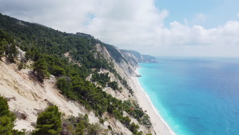 Eine-Drohne-Taucht-Aus-Dem-Wald-Entlang-Der-Küste-Des-Egremni-Strandes-In-Lefkada,-Griechenland-Auf