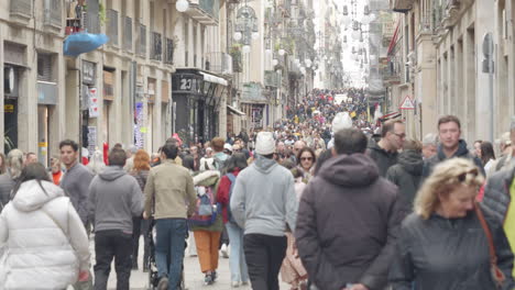 Crowd-walking-along-street-in-centre-of-Barcelona,-Spain