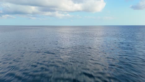 Aerial-dolly-on-deep-blue-Caribbean-ocean-tropical-sea-water-with-white-clouds-in-sky