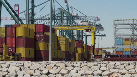 Containers-stacked-in-commercial-sea-port-of-Valencia-with-cranes-in-the-background