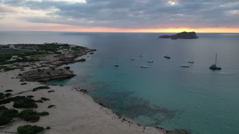 Strand-Von-Cala-Comte-Mit-Booten,-Atemberaubender-Sonnenuntergangshimmel-Auf-Ibiza