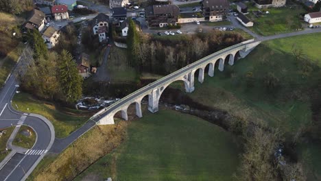 Historical-walking-bridge-over-a-river-in-Mieussy,-France