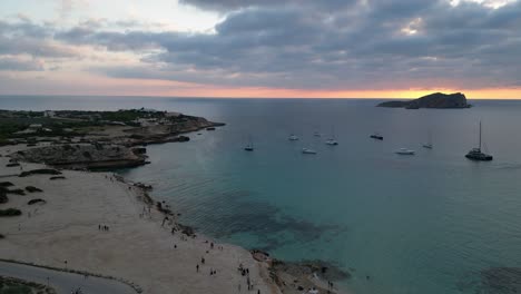 Strand-Von-Cala-Comte-Mit-Booten,-Atemberaubender-Sonnenuntergangshimmel-Auf-Ibiza