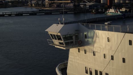 Ferry-of-the-moored-in-the-port-area,-the-wheelhouse,-and-several-cabin-windows,-illuminated-by-the-spring-sun's-rays